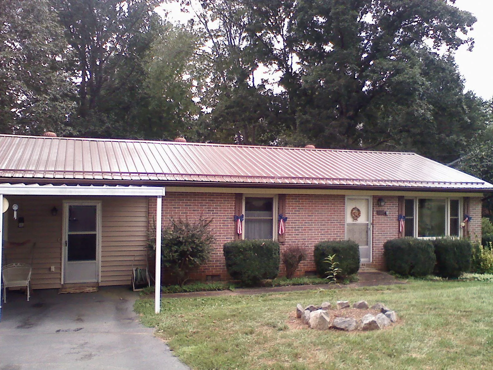 Bronze metal roof and carport on a brick ranch home — Roof Repair work by our crew in Conneaut